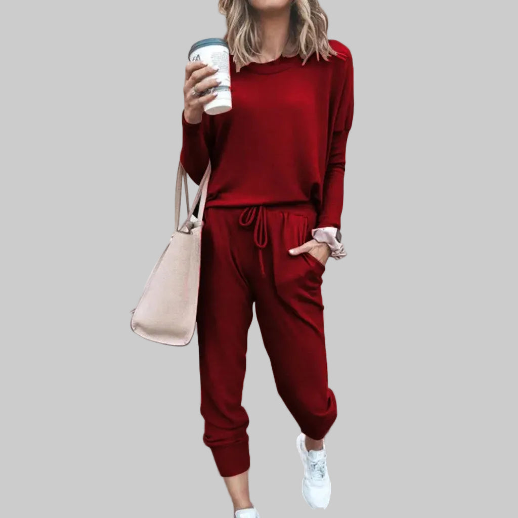 Person wearing a red outfit holding a coffee cup against a plain background