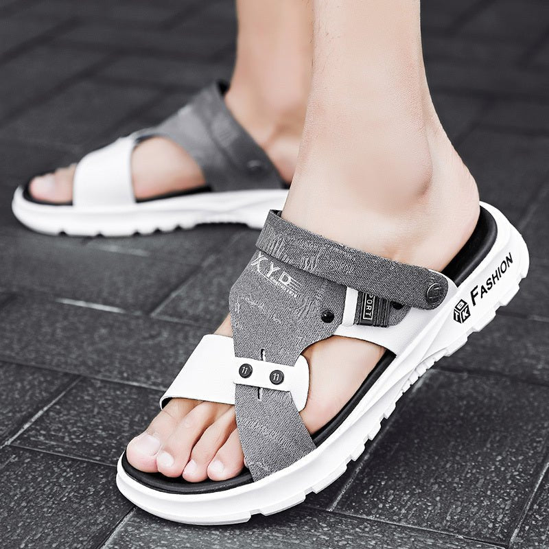 Gray sandals with white soles worn on a tiled floor