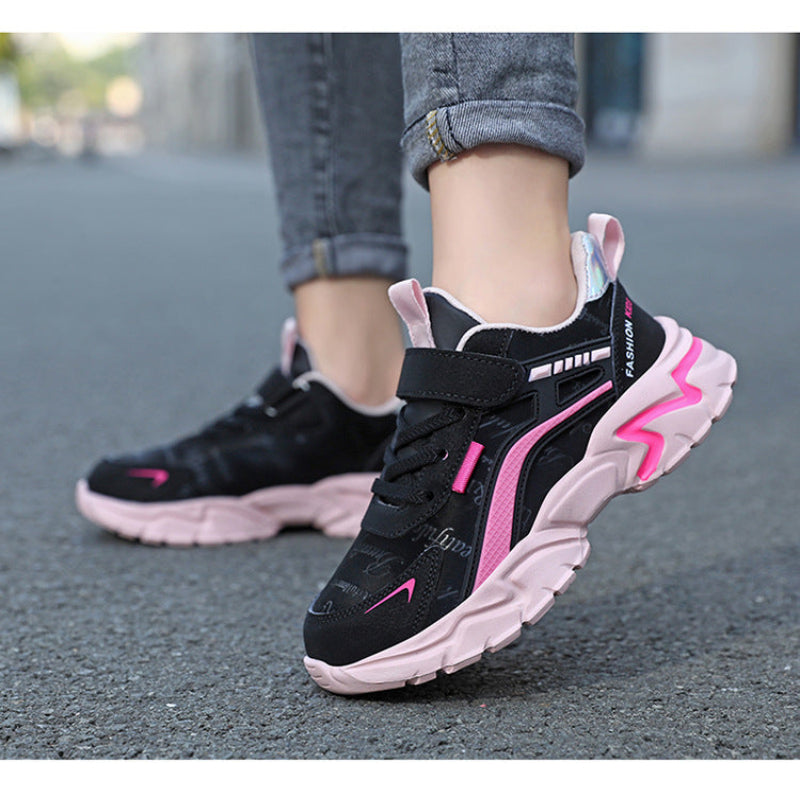 Black and pink sneakers worn on a blurred street background