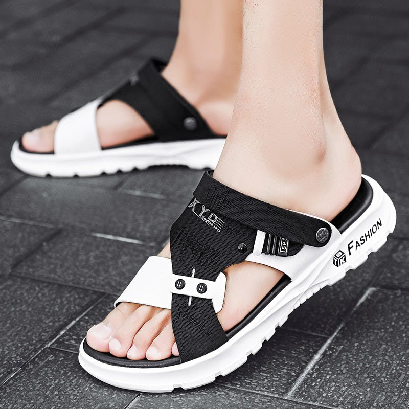 Black and white sandals with 'Fashion' text on a tiled floor