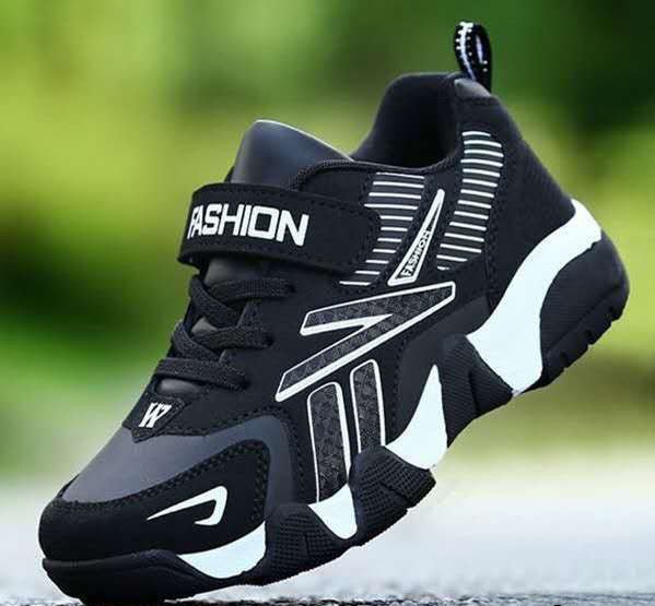A pair of kids' sport sneakers with a black and white design, featuring a lace-up closure and the word 'FASHION' printed on the side.