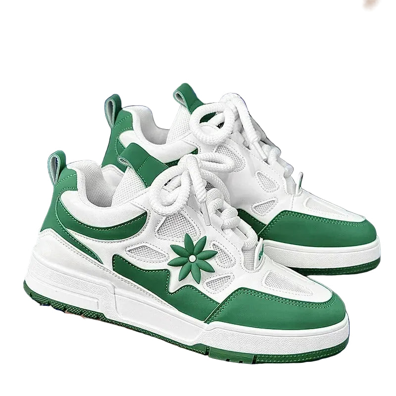 Green and white sneakers with a floral design held by a person 