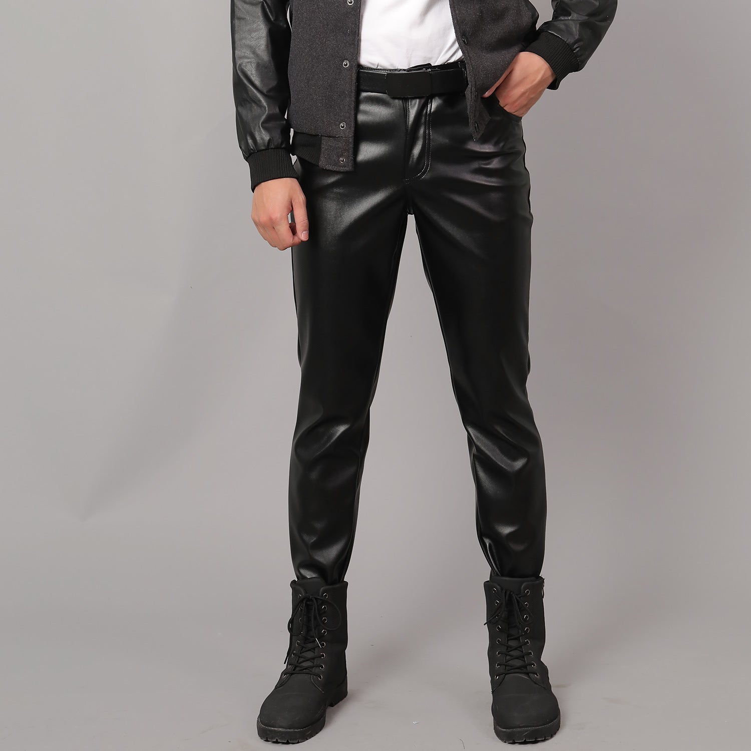 Person wearing Black Leather Pants for Men and black boots on a gray background