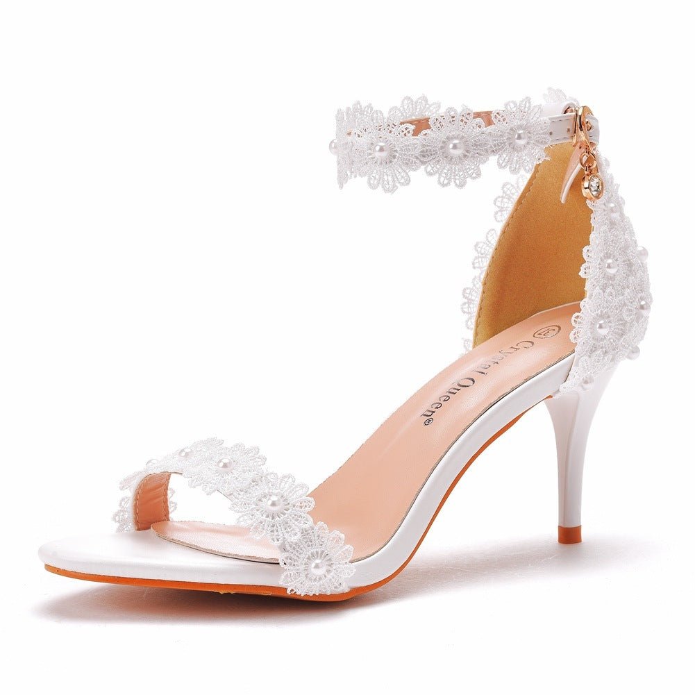 White high-heeled sandal with floral decorations on a white background