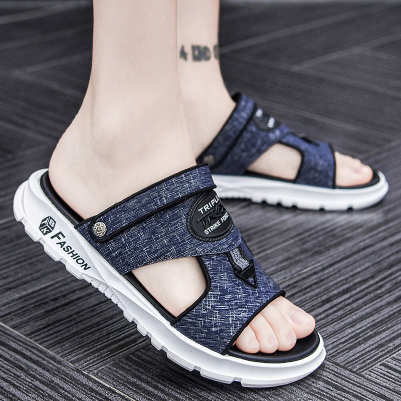 Blue sandals with white soles worn by a person on a gray floor.