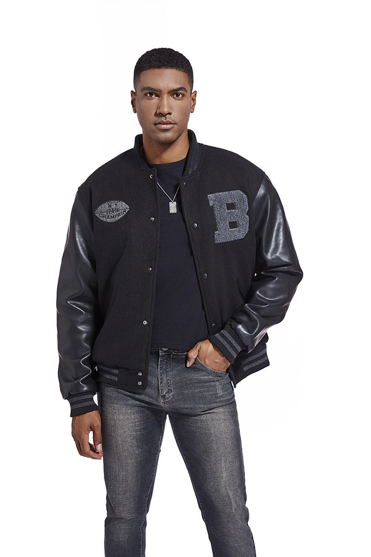 Man wearing a black varsity jacket with leather sleeves on a white background