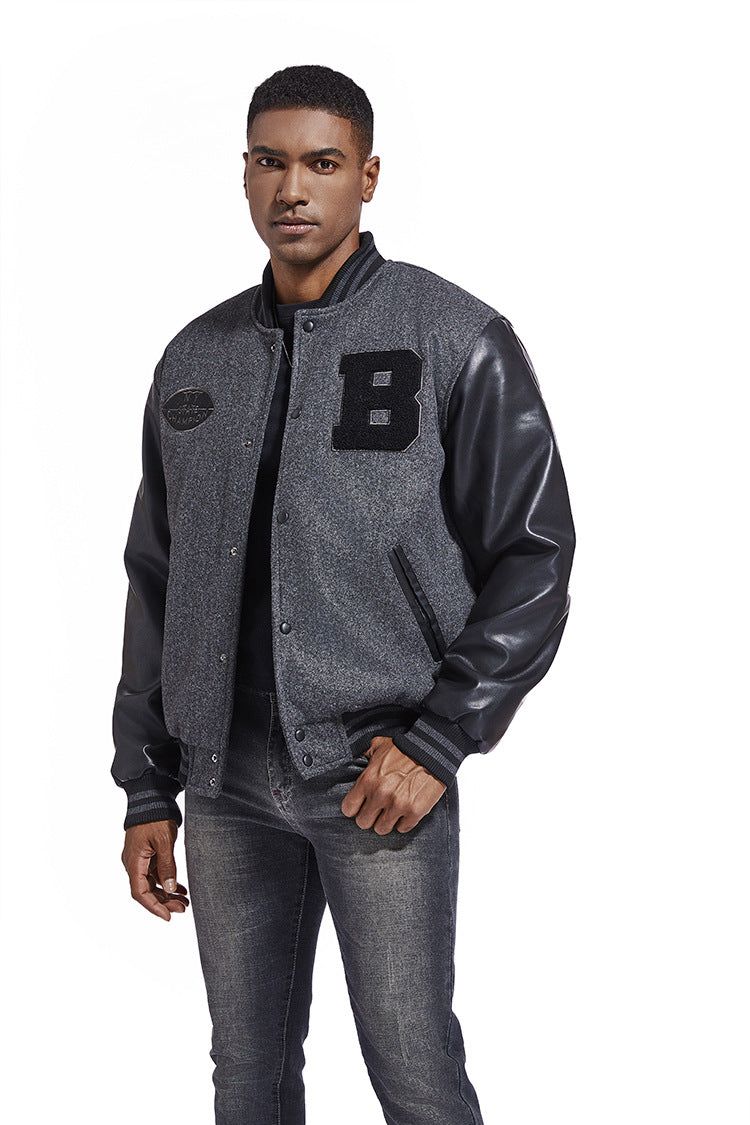 Man wearing a gray varsity jacket with black leather sleeves and a letter 'B' patch on a white background