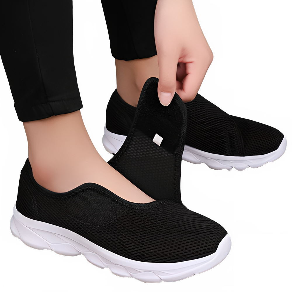 Women's Wide Fit Orthopedic Slip Black  Color  sneakers with white soles worn by a person on a white background