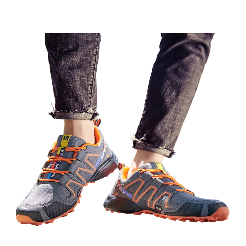 Gray and orange hiking shoes worn outdoors on a blurred natural background