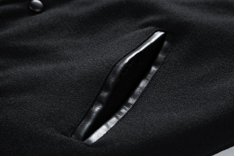 Close-up of a black coat with a button and pocket detail.