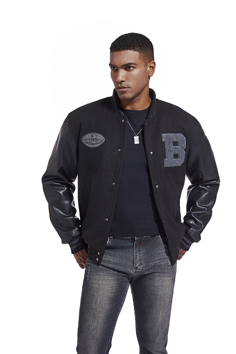 Man wearing a black varsity American Baseball Jacket with leather sleeves on a white background