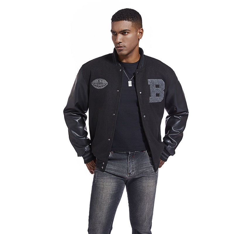 Man wearing a black varsity jacket with leather sleeves on a white background