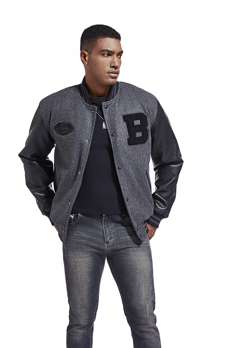 Man wearing a gray varsity jacket with a letter 'B' patch, black shirt, and gray jeans on a white background.