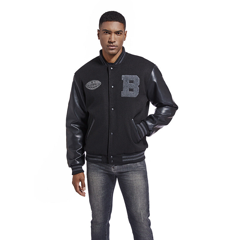 Man wearing a black varsity jacket with leather sleeves on a white background