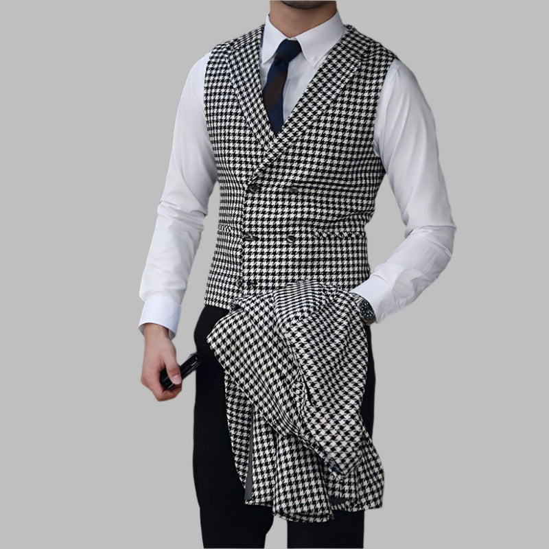 Person wearing a black and white checkered vest over a white shirt with a gray background