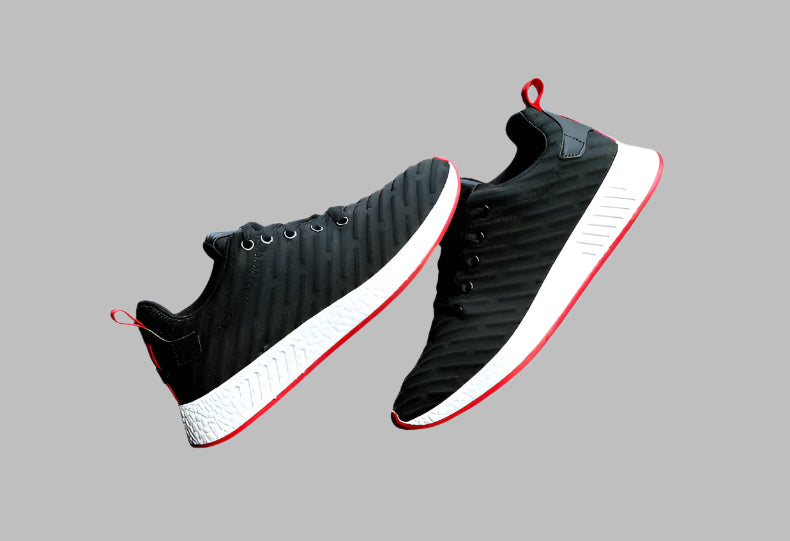 Black and white sneakers with red accents on a car seat