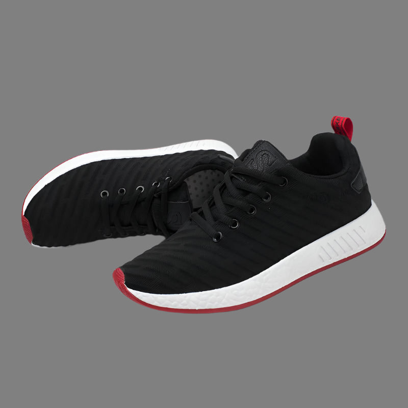 Black sneakers with red accents on a white background