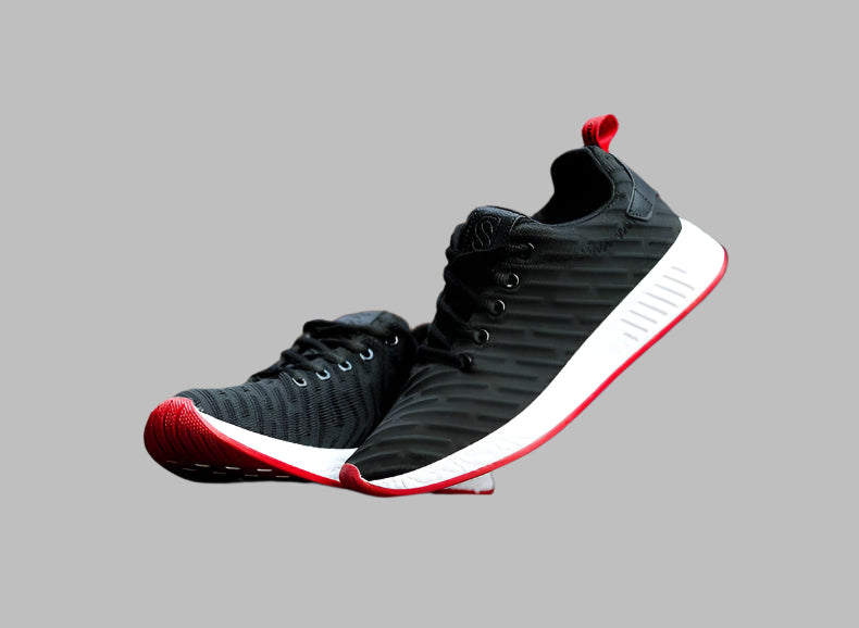 Black and red athletic shoes on a gray background