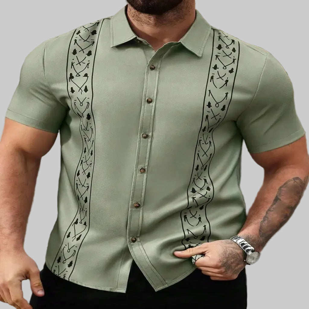 Man wearing a green guayabera shirt with black embroidery.