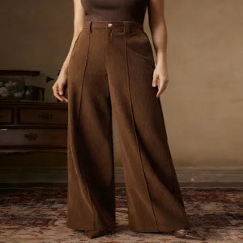 Brown wide-leg pants worn by a person in a room with a vintage rug and wooden furniture.