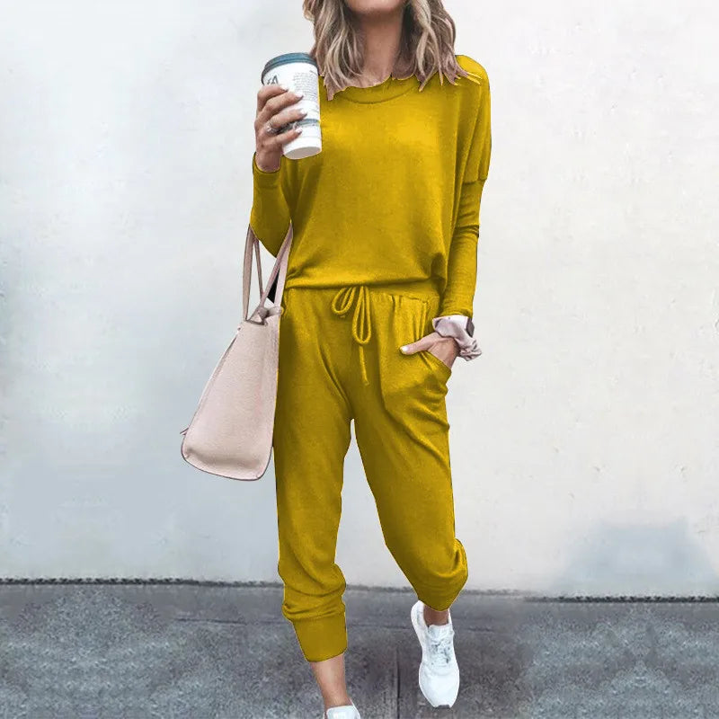 Person wearing a mustard yellow outfit holding a coffee cup against a plain background