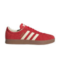 Red Adidas sneaker with white stripes on a light gray background