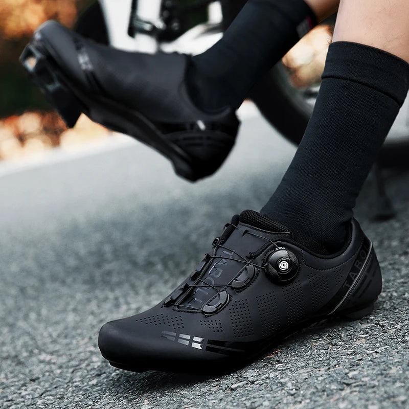 Black cycling shoes worn on a road with blurred background