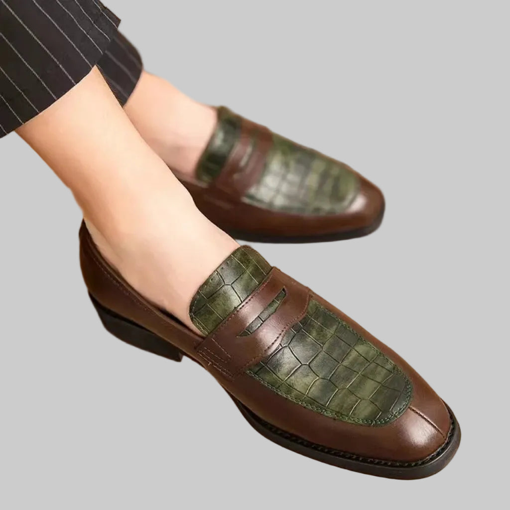 Brown and green loafers on a wooden floor
