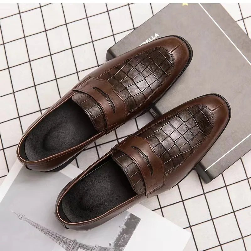 Pair of brown leather loafers on a checkered surface