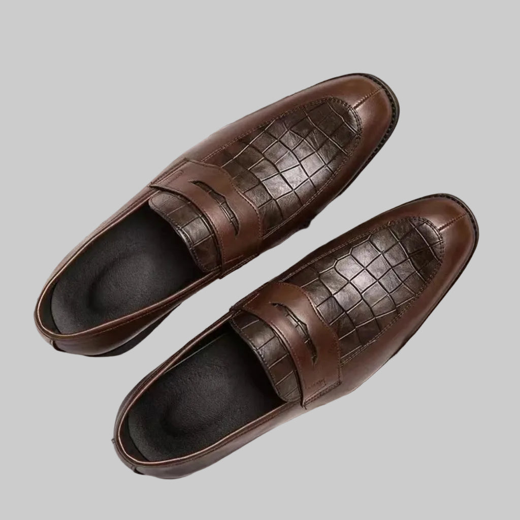 Pair of brown leather loafers on a checkered surface