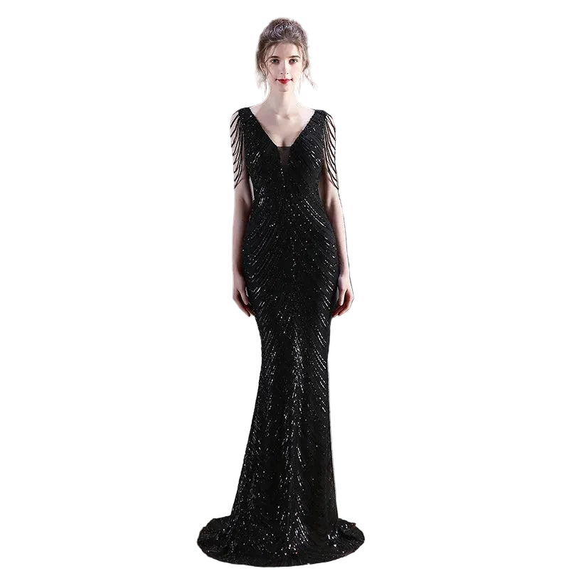Woman wearing a black sequin evening gown in an indoor setting.