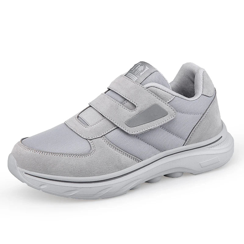 Gray athletic shoe with velcro straps on a white background