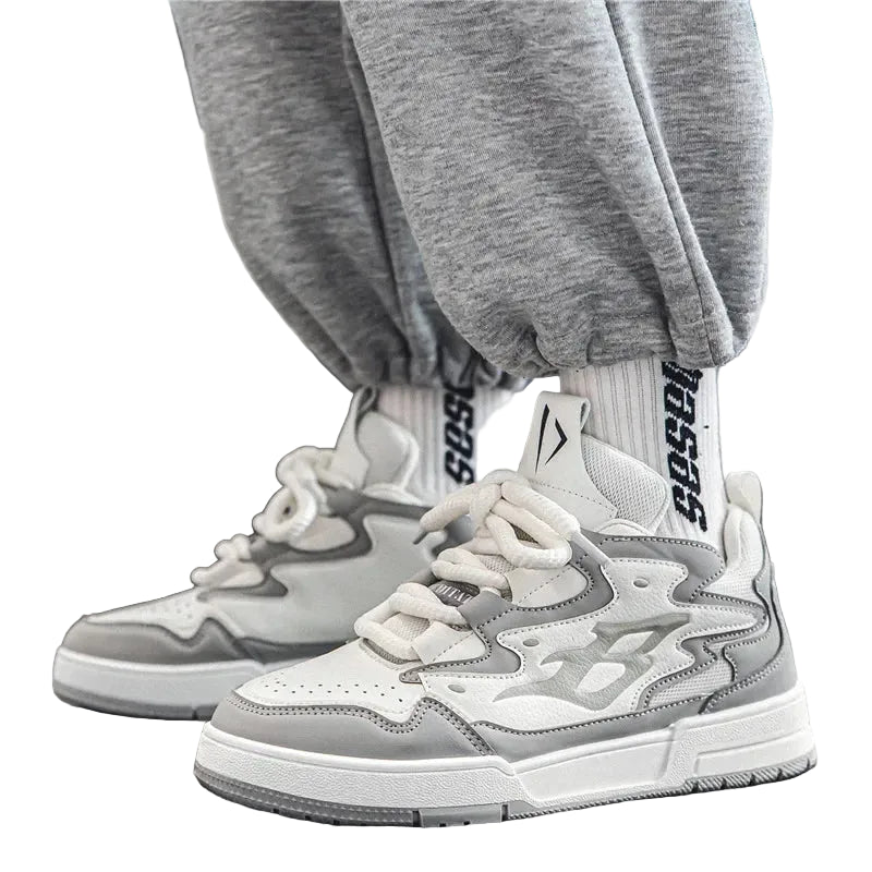 Gray and white sneakers worn with gray pants on a neutral background