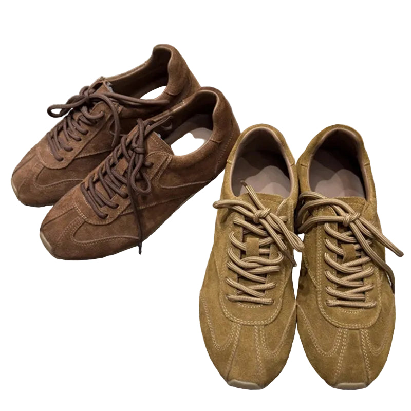 Pair of brown suede sneakers on a textured surface