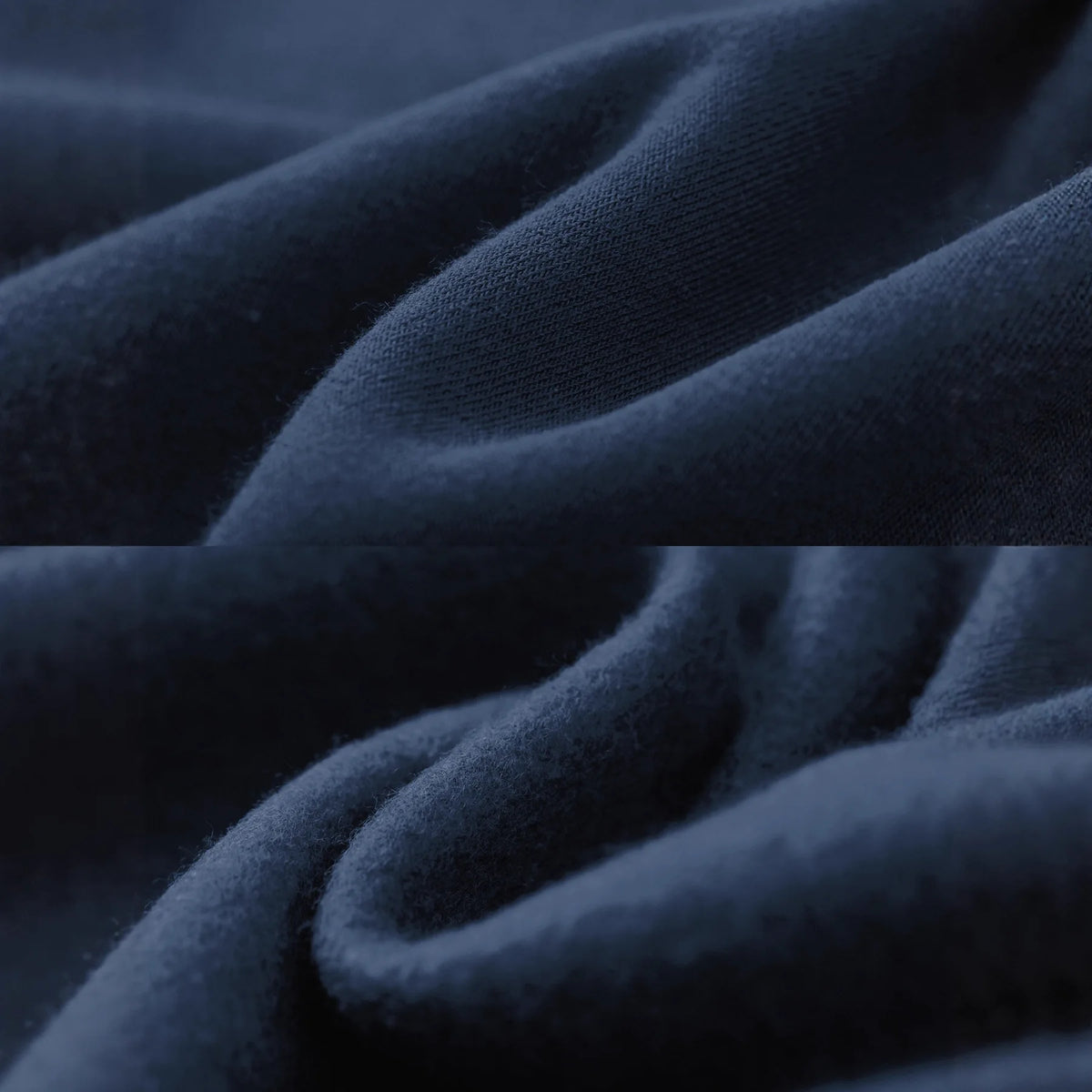 A close-up of draped dark navy blue fabric with soft folds and a smooth, slightly textured surface.