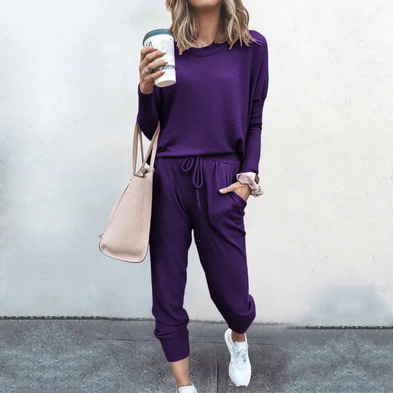 Person wearing a purple outfit holding a coffee cup against a plain background