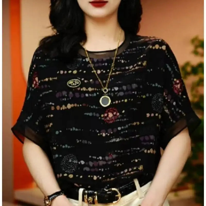 Woman wearing a black floral blouse with a blurred background