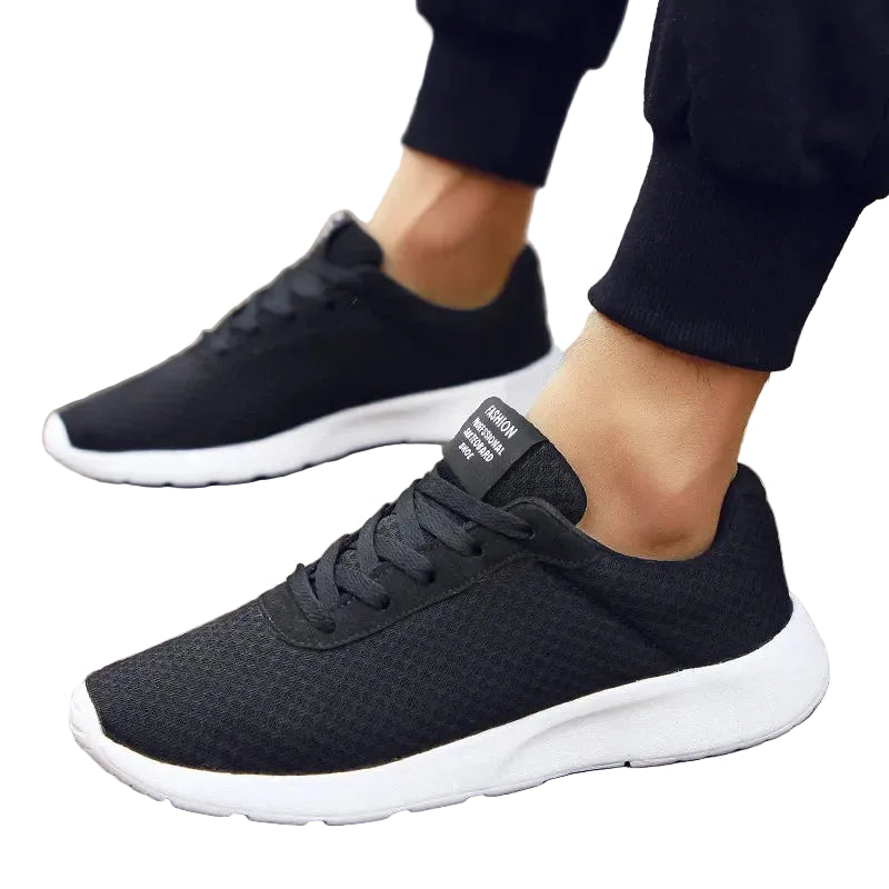 Side view of Men's Malcom Sneaker in black featuring a lightweight design and flexible white sole.
