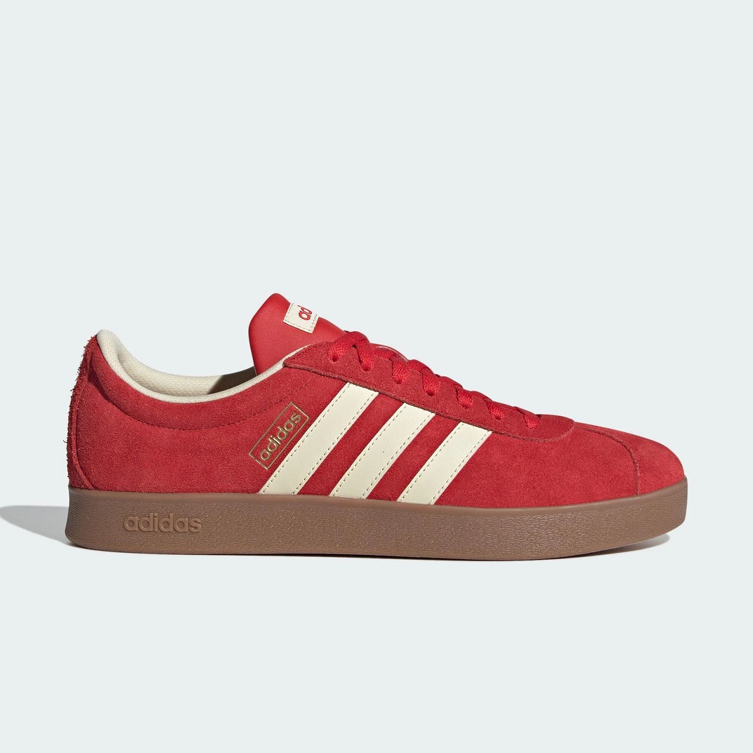 Red Adidas sneaker with white stripes on a light gray background