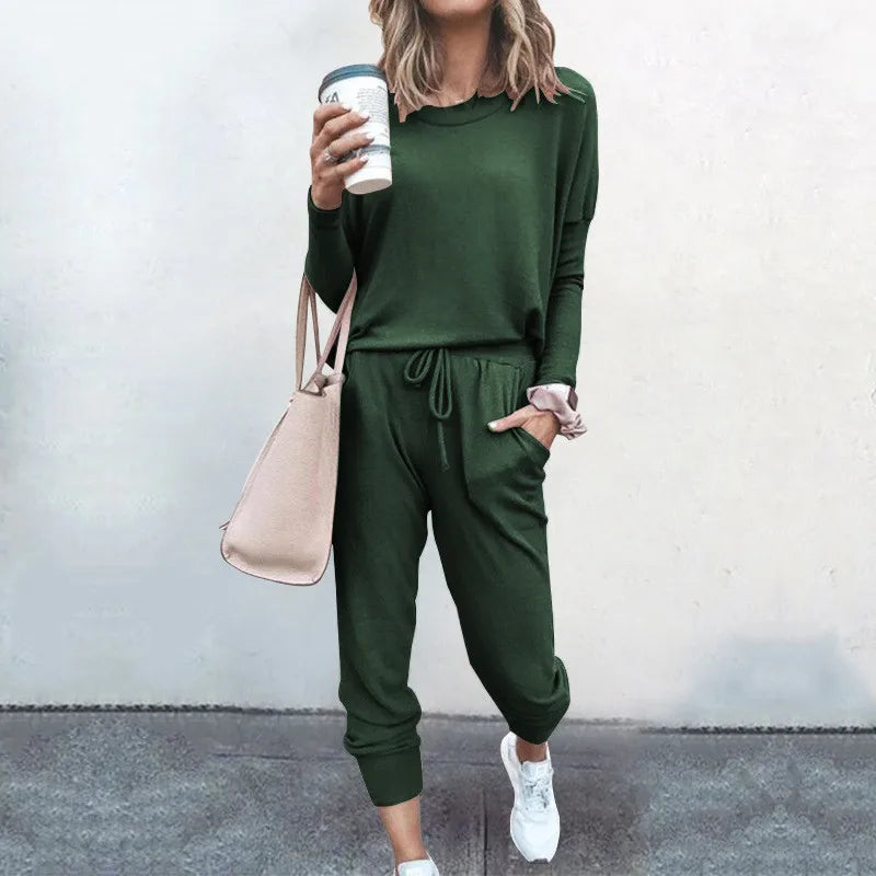 Person wearing a green outfit holding a coffee cup against a plain background