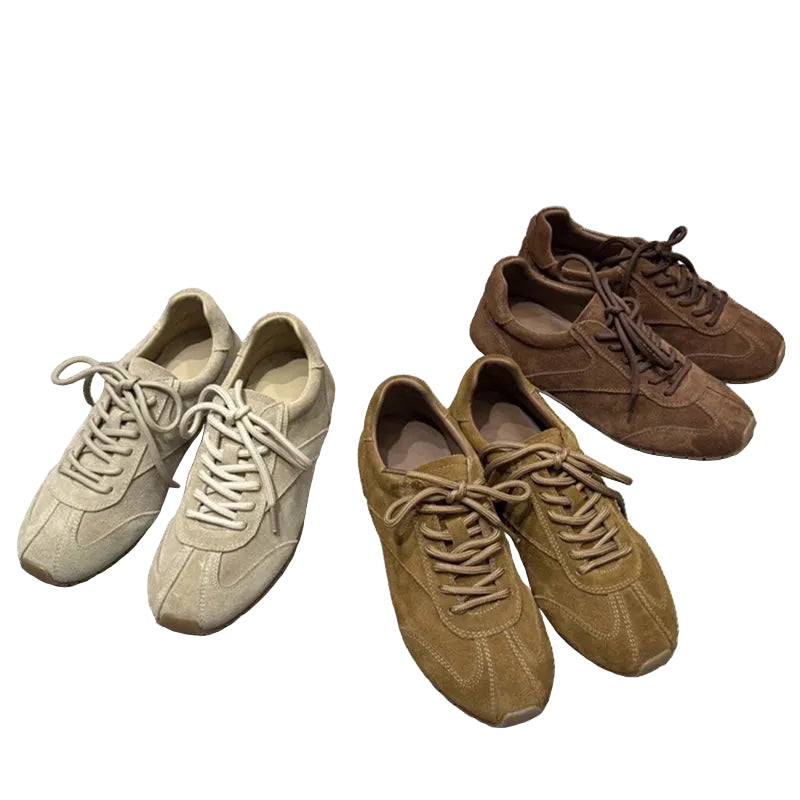 Two pairs of brown and beige sneakers on a gray textured surface