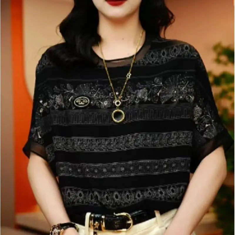 Person wearing a black lace top with a blurred background