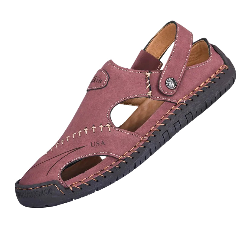 Pink sandal with brown stitching on a white stand against a black background