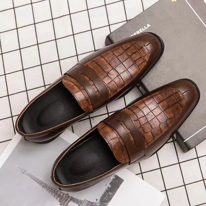 Brown crocodile-patterned loafers on a checkered background