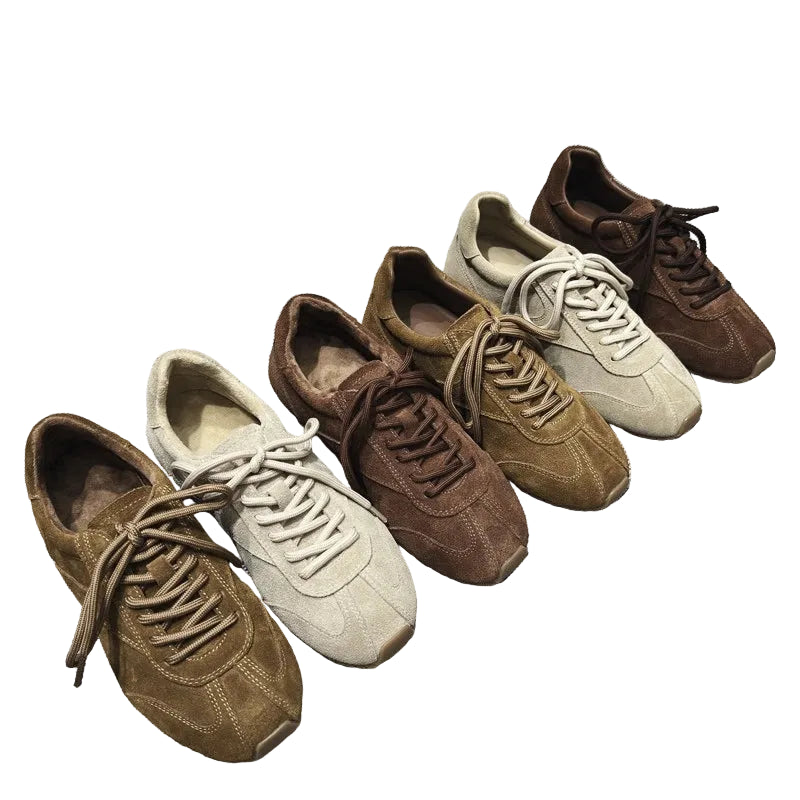 Set of brown and beige sneakers on a textured gray surface