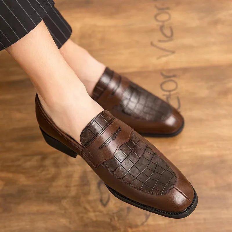 Brown loafers worn by a person on a wooden floor