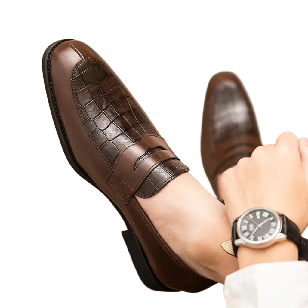 A brown crocodile-patterned leather shoe being worn by a person, focusing on the design and fit.