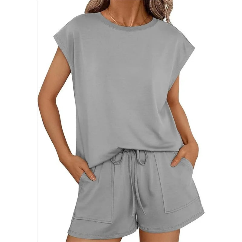 Woman wearing a gray outfit with a top and shorts on a white background