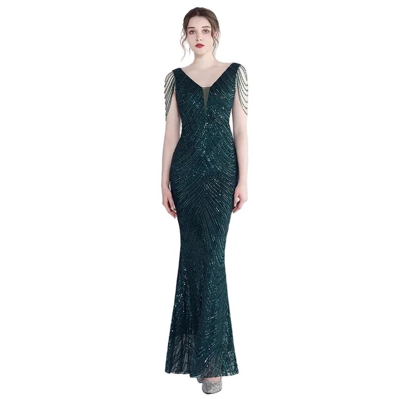 Woman wearing a dark green evening gown with beaded sleeves on a white background