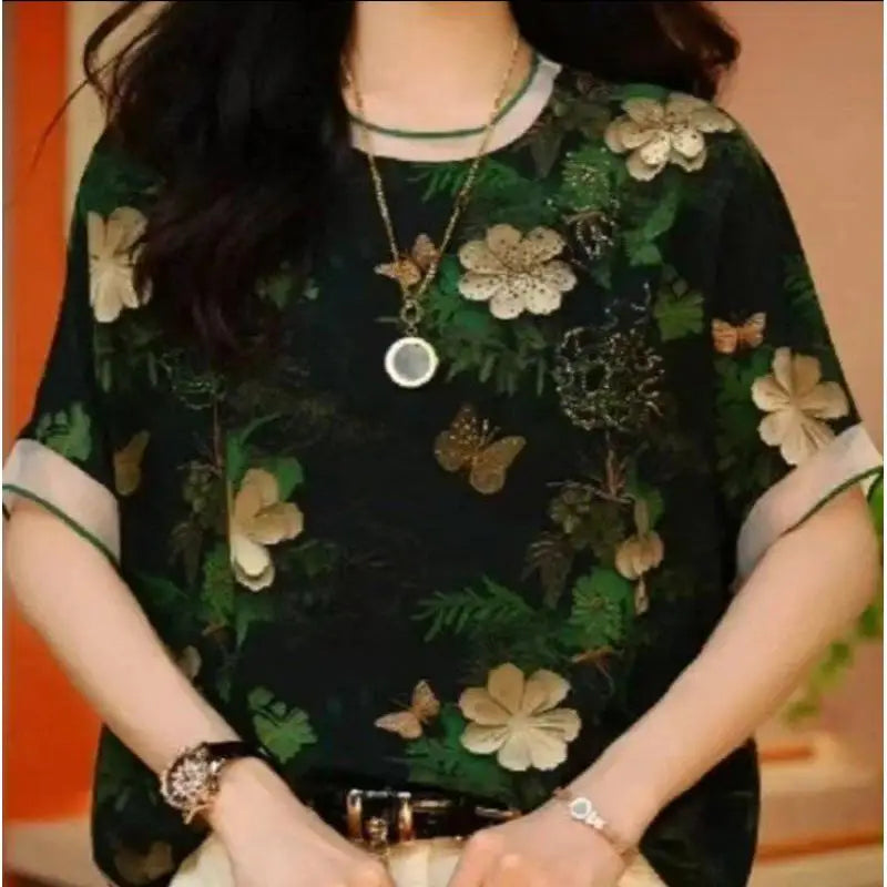 Person wearing a floral dress with a green and black color scheme.